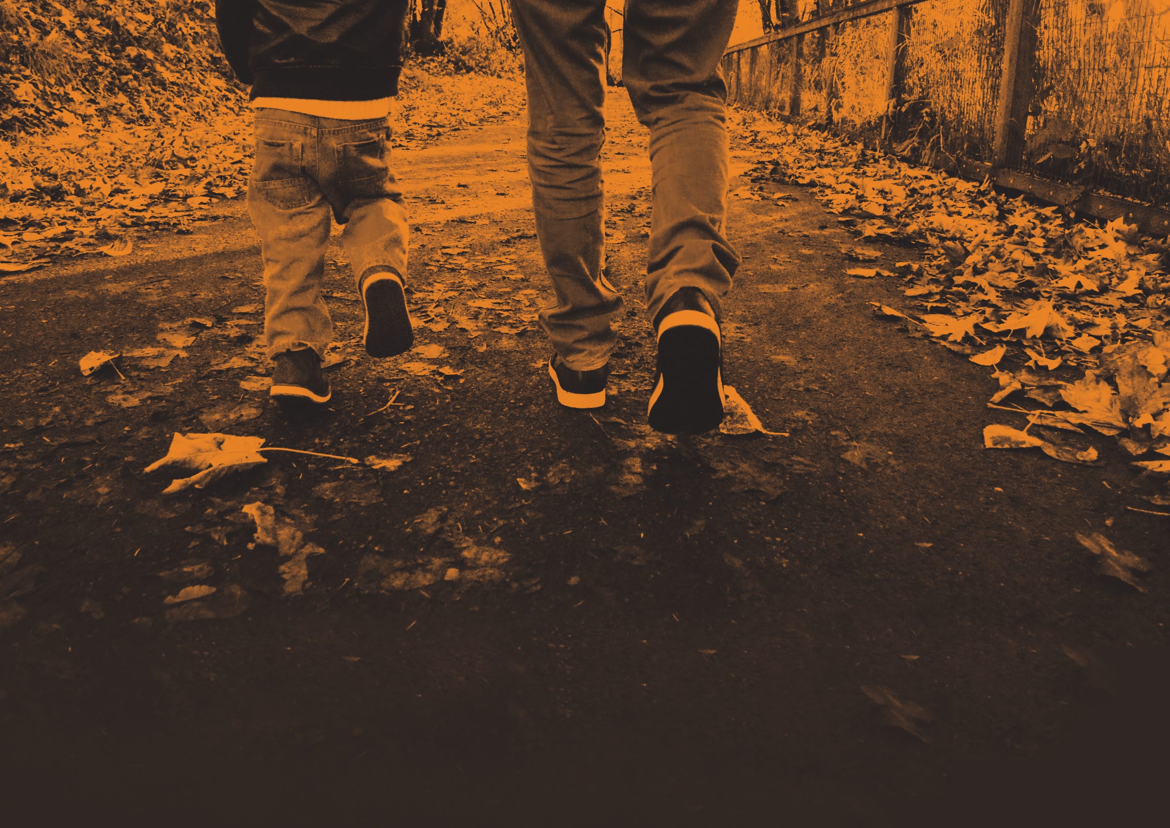 The feet of a father and son walking together in nature. Les pieds d'un père et d’un fils marchant ensemble dans la nature.